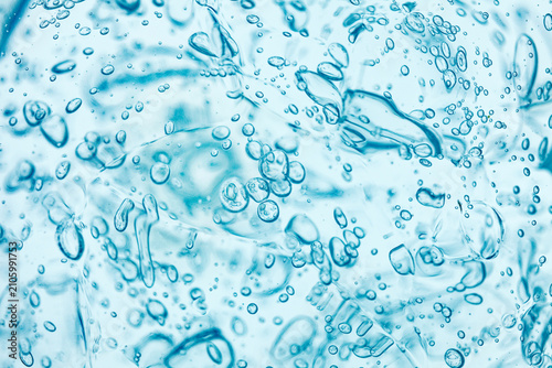 Abstract light blue gel texture with bubbles. Clear cosmetic liquid smudge smear background. Hydrating hyaluronic acid skincare product macro backdrop. Serum cream stabilizer moisturizer consistency.