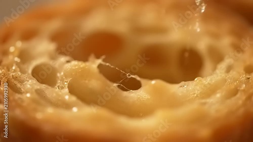Macro shot of honeycomb air pockets inside a freshly baked golden croissant pastry