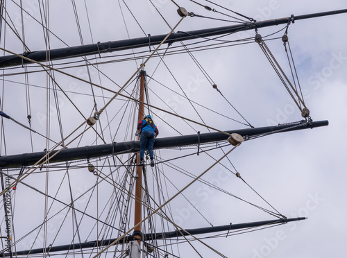 Photography A tourist scaling the rigging of the iconic Cutty Sark tea clipper docked in Gre