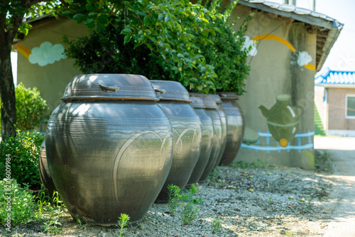 Photos Five traditional Korean earthenware jars lined up outdoors