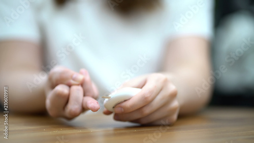Woman carefully pricks her finger to collect a blood sample for medical analysis and laboratory testing.