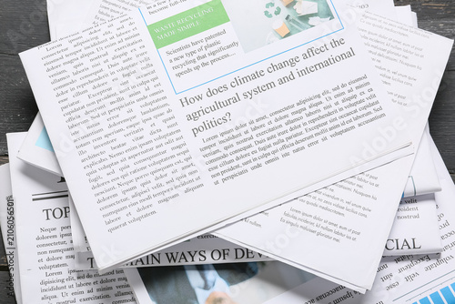 Obraz na plátne Stack of newspapers with climate change and recycling headlines, global politics