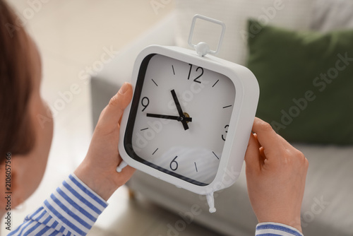 Woman changing clock for da...