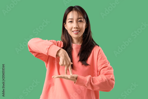 Young happy Asian woman usi...