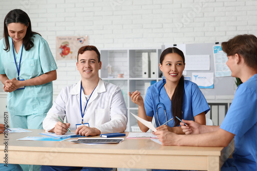 Group of young doctors working at table in clinic