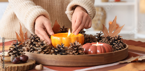 Woman lighting a pumpkin-sh...