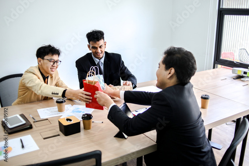 Young Asian Professional in Formal Suits Exchanging Gifts and Celebrating an Occasion