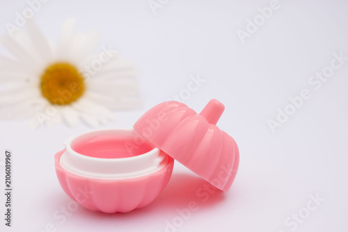 Pink lipstick with daisy flower on pastel background