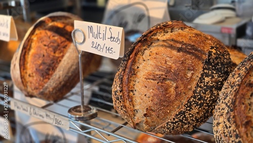 Loaf of bread with seeds.Whole grain churdough bread sits on the shelves in the bakery. The bread has a crisp, golden crust and a beautiful pattern, freshly baked from a variety of grains and seeds.