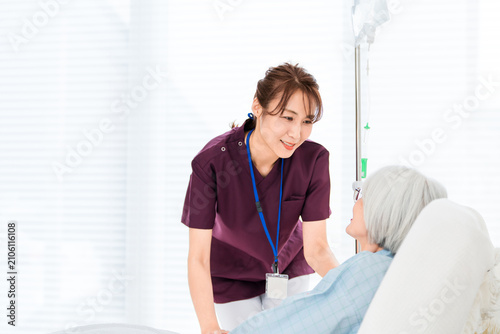 Canvas Print リクライニングベッドにいるシニア女性患者と看護師,介護士の女性スタッフ（医療イメージ）
