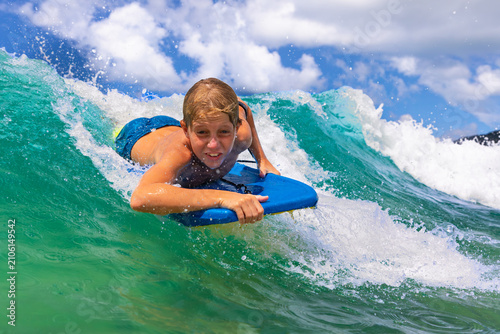 Bild auf Leinwand Happy young surfer boy with bodyboard have fun on beach, riding on small ocean waves