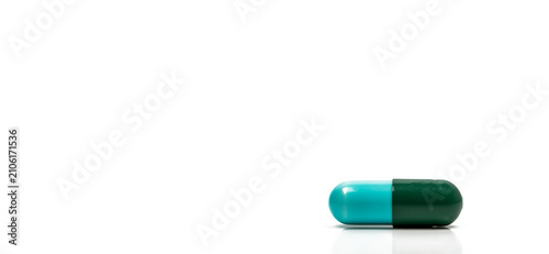 Quadro su tela Blue and green antibiotic capsule pills isolated on white background in global healthcare concept showing antimicrobial resistance awareness and responsible drug use for infection treatment