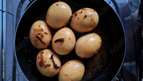 Photos Boiled soy eggs simmer in a dark pan, showcasing a traditional Asian cooking technique for flavorful protein snacks in a rustic kitchen setting
