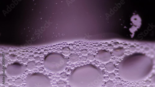 Macro footage of soap bubbles in glass container