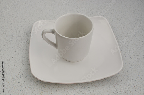 Valokuva Closeup of an empty porcelain cup on a white plate, representing finesse and delicacy