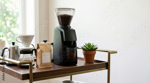 Black electric coffee grinder and brewing equipment on a wooden bar cart. Home coffee station with pour over maker and gooseneck kettle. Blank label on paper bag for copy space