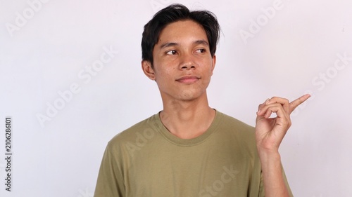Konstfotografi young asian man pointing and glancing sideways