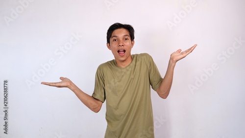 Bild auf Leinwand Asian young man gestures clueless raising both hands