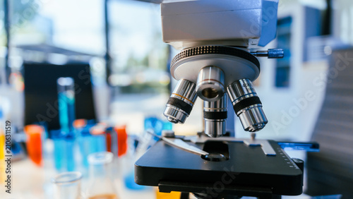 Fotografía Close-up of a microscope in a modern laboratory with blurred test tubes and glas