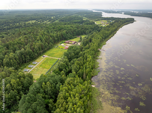 Aerial view of a small holiday resort and sub-divided land plots by a quiet forest lake on an overcast summer day in Karelia, Russia
