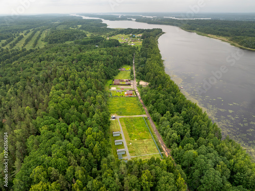 Aerial view of a small holiday resort and sub-divided land plots by a quiet forest lake on an overcast summer day in Karelia, Russia