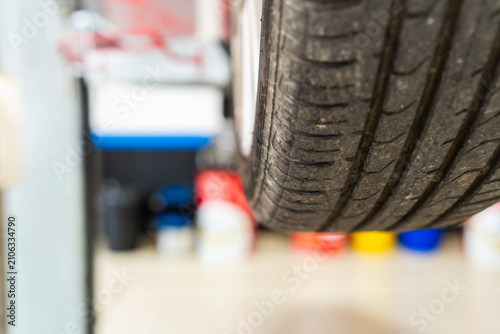 Фотография Car tire rotating on lift for service