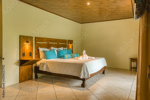 Canvastavla Elegant hotel room offering comfortable bed and tropical ambiance