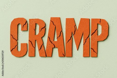Cramp text craft art with jagged crack effect in orange red color, rough paper texture on pale mint green background