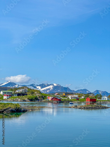 Canvas Print Colorful traditional wooden houses and red rorbuer sit along the calm coast of S