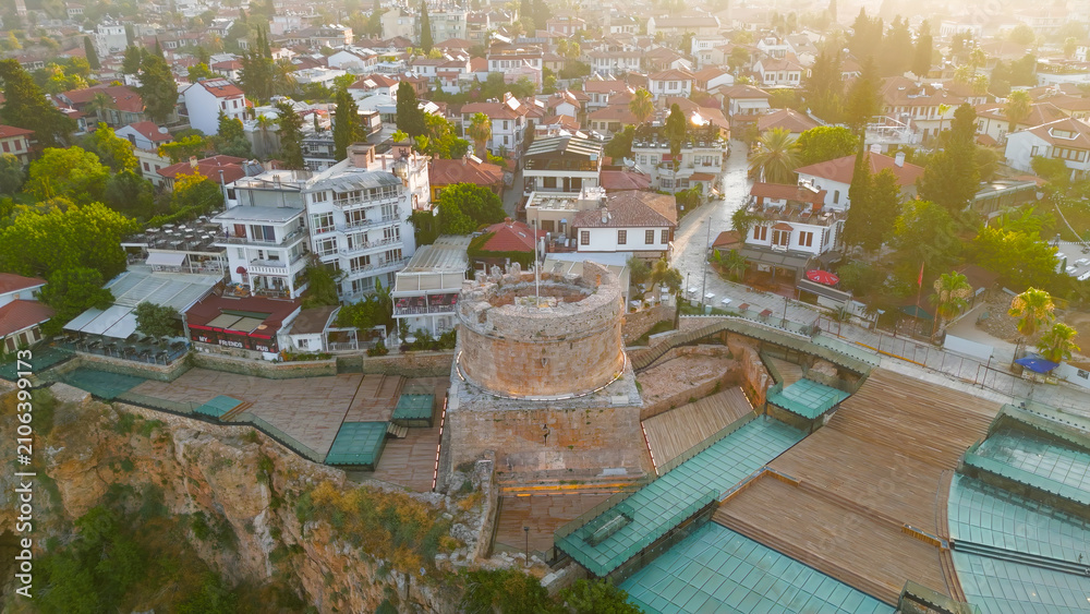 Fototapeta premium Antalya, Turkey. Aerial drone view of Hidirlik Tower integrated with Kaleici Old Town architecture and narrow streets in warm morning light.. Aerial View