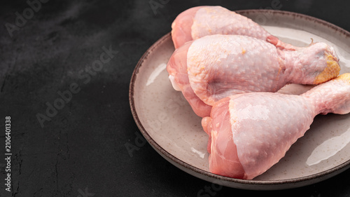 Raw chicken leg or drumstick isolated on black  background 