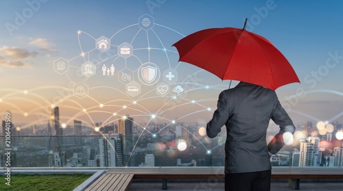 Businessman with red umbrella standing on rooftop looking at city skyline with floating icons representing insurance protection, security and social safety net services