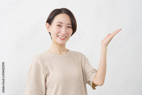 Foto 手のひらで指し示し案内する女性　白背景