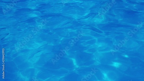 Sparkling blue pool water surface with rippling light patterns
