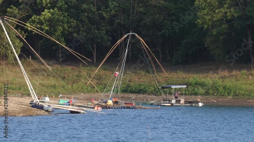 Traditional giant dip nets installed along the lake shore surrounded by green nature