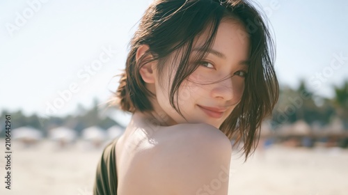 Beautiful young asian woman smiling gracefully on sunny summer beach