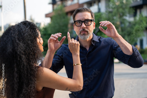 Man exploring AR glasses while woman observing city view outdoors