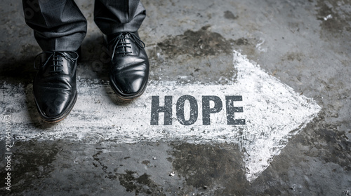 The Path to Hope: A person stands at a crossroads, their polished shoes resting beside an arrow marked HOPE, symbolizing a decisive step toward a brighter future.