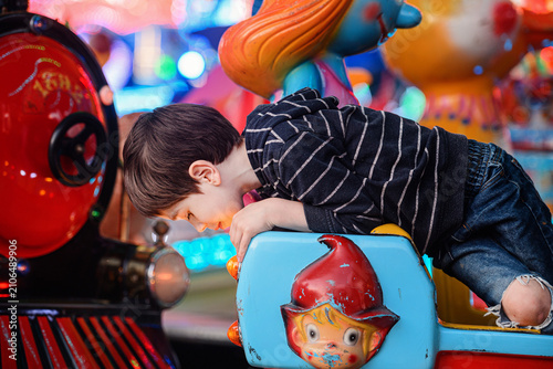 Low angle pensive boy looking left in high red car and helicopter ride dusk