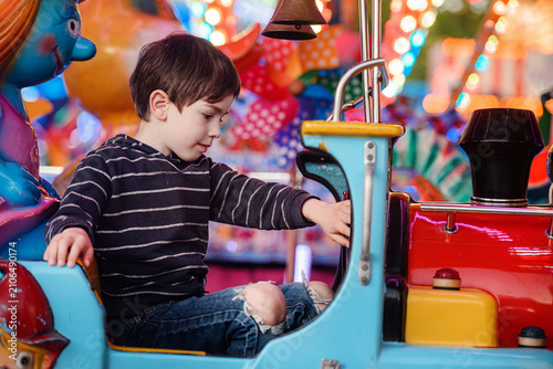 Low angle boy pensive observe high in red car ride blue sky dusk prop