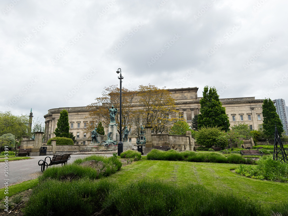 Fototapeta premium Historic neoclassical St Georges Hall civic building and statue in a park on an overcast day at Liverpool, UK