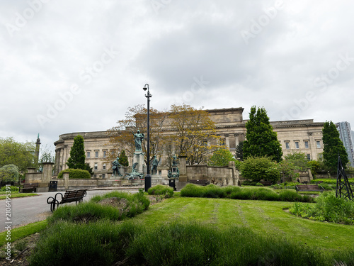 Historic neoclassical St Georges Hall civic building and statue in a park on an overcast day at Liverpool, UK