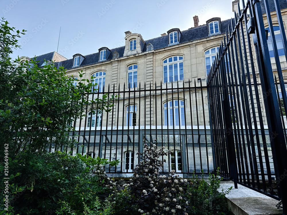 Obraz premium Historic Paris, France Luxembourg Palace building with wrought iron fence and garden framing classical stone facade under clear blue sky
