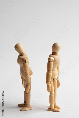 two wooden figures with their backs to each other