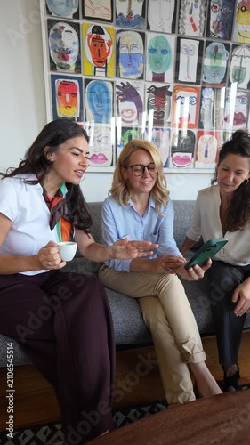 Three businesswomen having fun watching smartphone content
