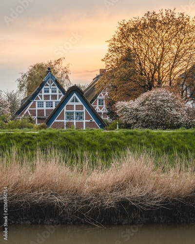Germany, Altes Land, Jork, Idyllic rural scene with half timbered houses in spring at sunset
