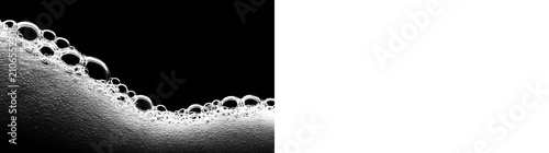 Fotografie White soap suds and foam wave on black and transparent background