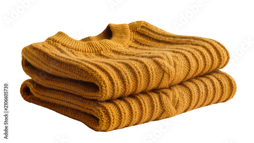 Isolated Two neatly folded mustard yellow chunky knit sweaters, warm and cozy winter fashion.