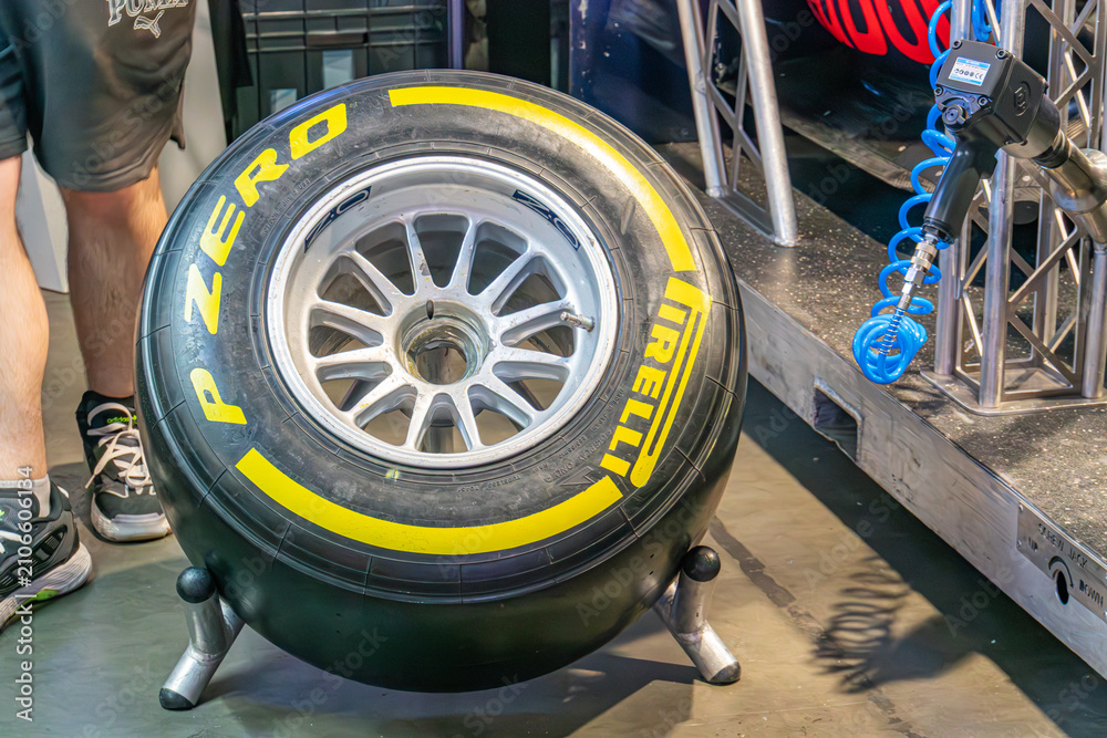 Obraz premium Close-up image of a Formula 1 wheel on a tire changer machine in a garage setting The wheel is black with yellow and white lettering, possibly indicating brand or m - Kyiv, Ukraine - June 7, 2025