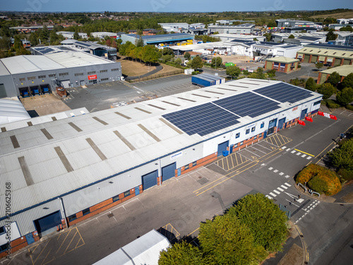 Aerial View of Modern Industrial Warehouse Complex in Green Countryside at Sunset – Commercial Buildings in Rural Setting